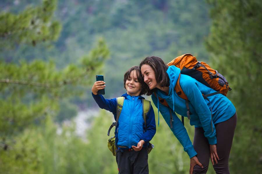 Young boy and his mom taking a selfie in nature