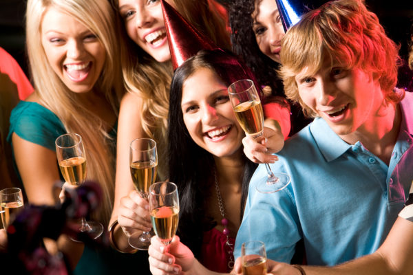 Image of people with hats holding glasses of champagne