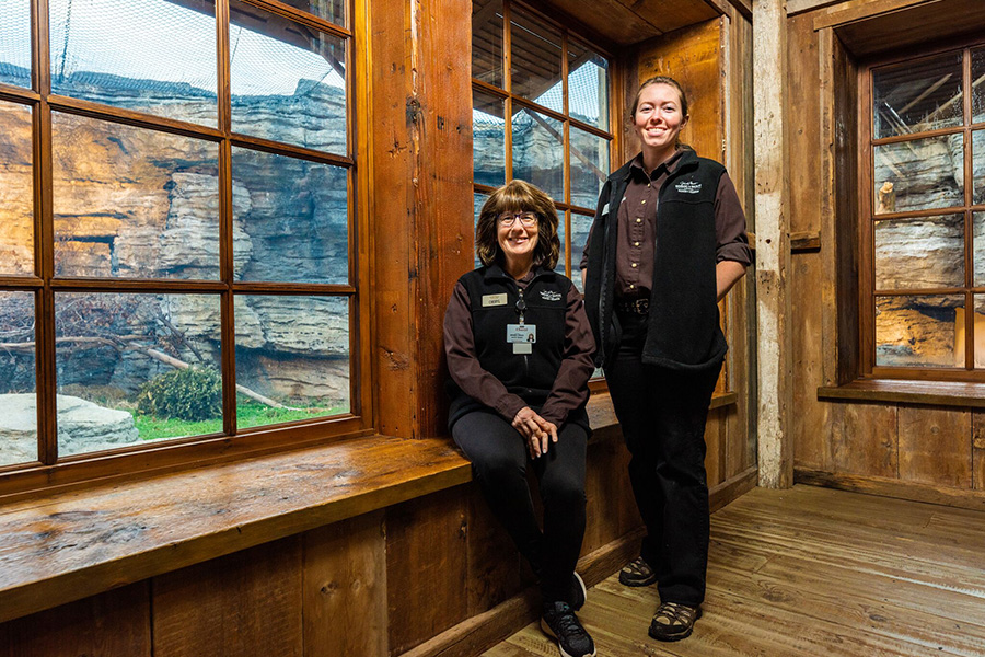 Two volunteers pose for a photo in the bear cabin at Wonders of Wildlife.